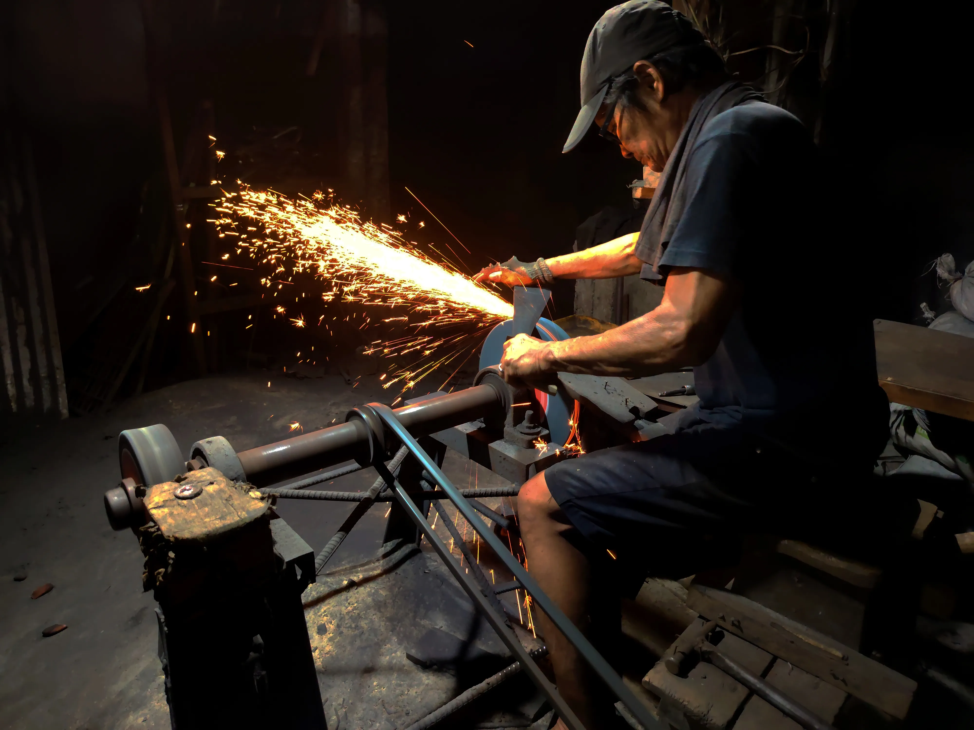 An image of a man using a grinder to sharpen a tool